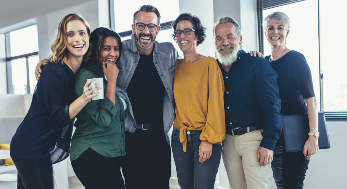 Groupe de personnes souriantes, debout dans une file d'attente