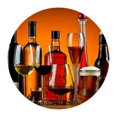Bottles and glasses of alcohol, in front of an orange background.