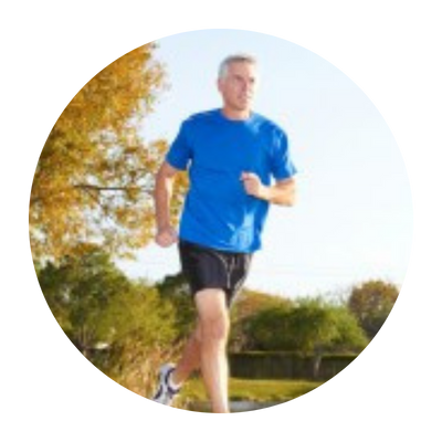 Man in a blue shirt, running through a park.