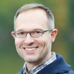 Man in glasses, smiling at the camera. 